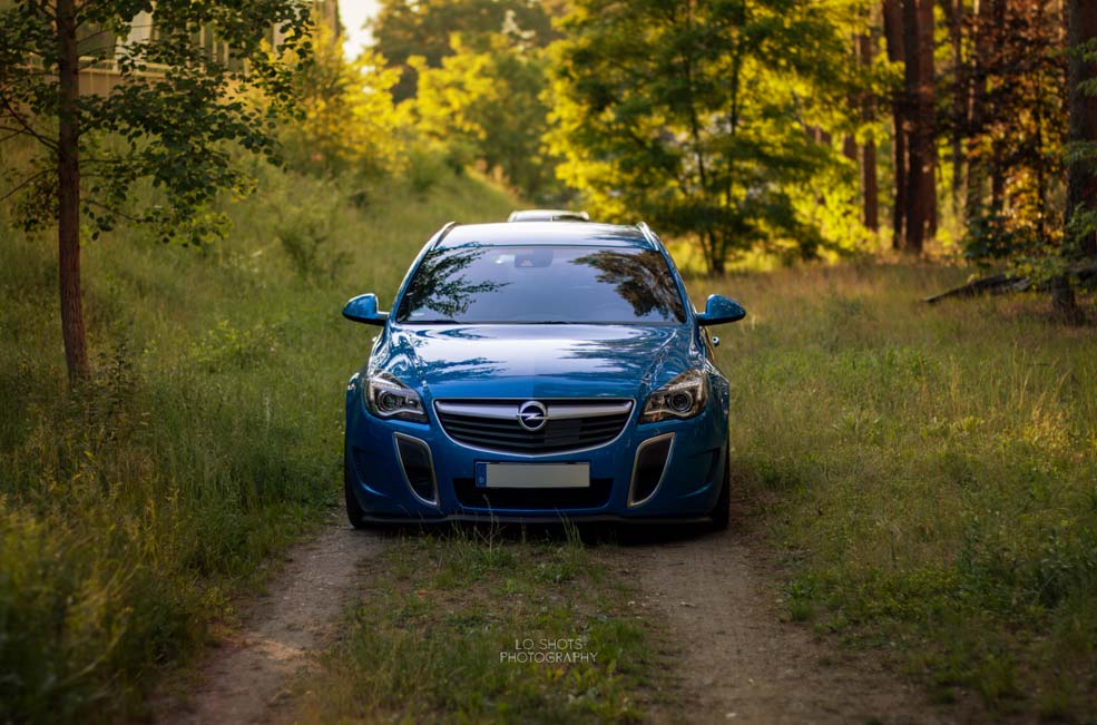 fahrzeugfotografie_ein_blauer_opel_steht_auf_einem_waldpfad