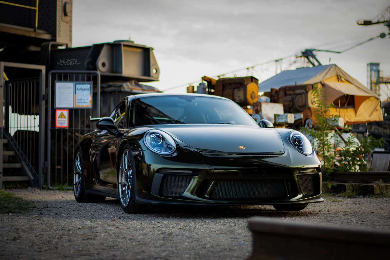 fahrzeugfotografie_ein_dunkelgruener_porsche_steht_vor_einem_industriegelaende