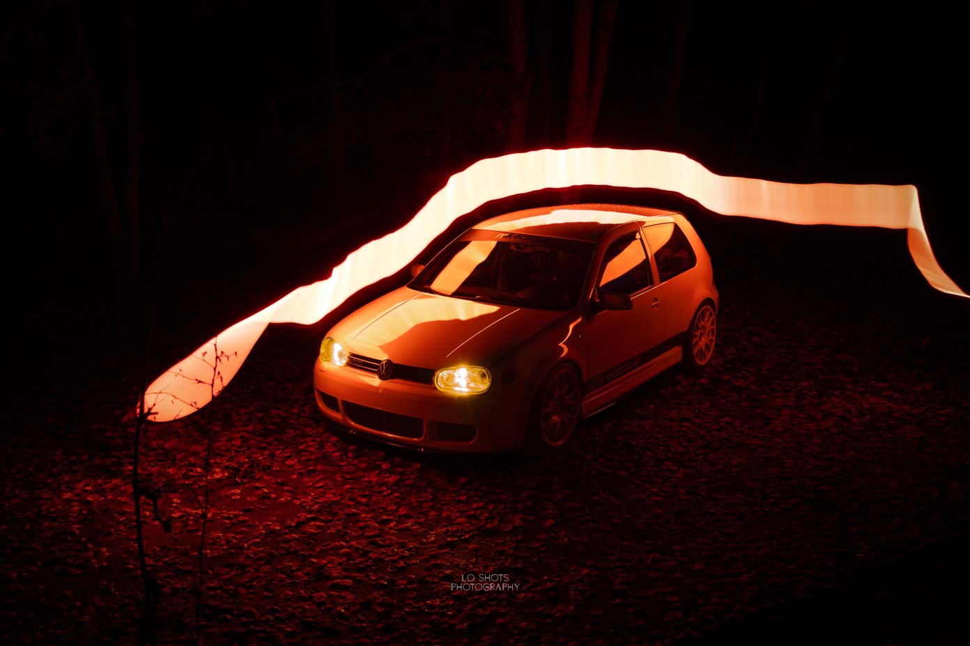 fahrzeugfotografie_ein_gelber_golf_vier_steht_in_einem_dunklen_wald_im_hintergrund_lichtelemente