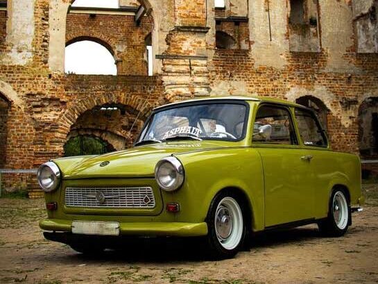fahrzeugfotografie_ein_gruener_trabant_steht_in_einem_innenhof_einer_burgruine_im_hintergrund_burgmauern